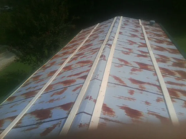 Rusted metal roof panels with new wood purlins before replacement — Storm Damage Roof Repair in Greenvale by Roofing Brothers