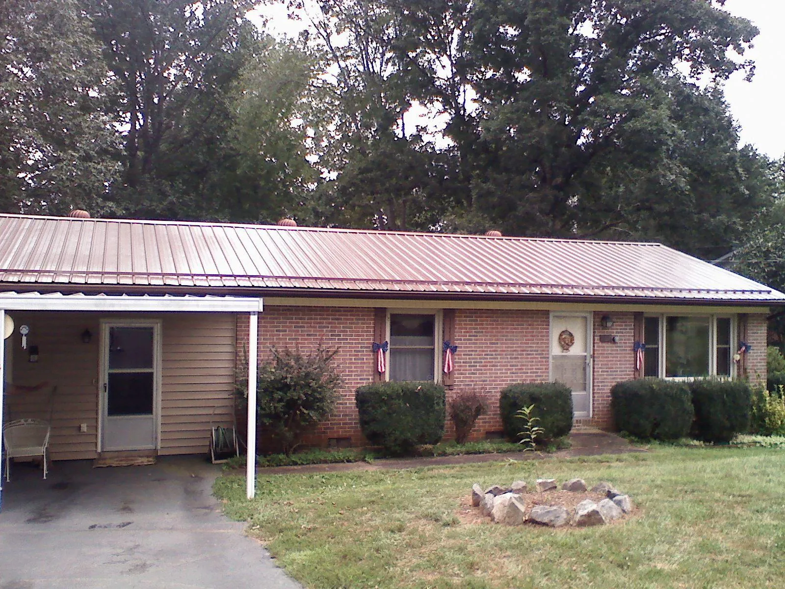 Bronze metal roof and carport on a brick ranch home — Roof Repair work by our crew in Greenvale